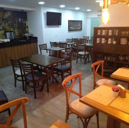 a dining room with wooden tables and chairs at Hotel Guarulhos in Sao Paulo