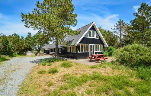 a black house with a picnic table in front of it at Holiday Home Froidal Rømø in Toftum