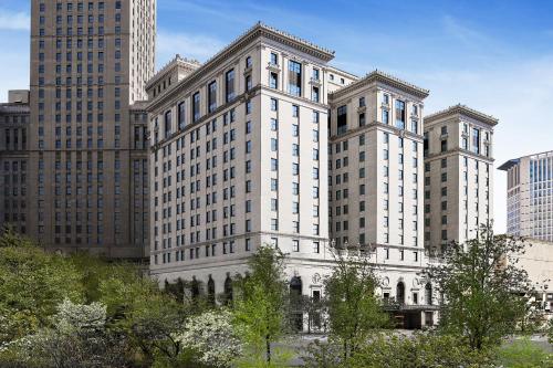 a large white building in a city with tall buildings at Hotel Cleveland Autograph Collection in Cleveland