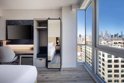 a hotel room with a desk and a large window at Courtyard by Marriott New York Manhattan / Soho in New York