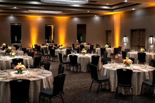 a banquet room with tables and chairs with white tablecloths at Marriott Melville Long Island in Melville