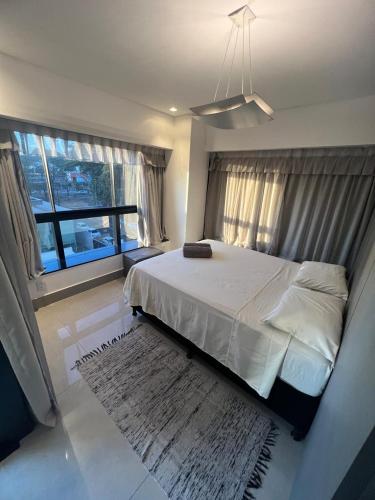 a bedroom with a large bed and a rug at Loft moderno e Hi- tech Vertigo in Campo Grande