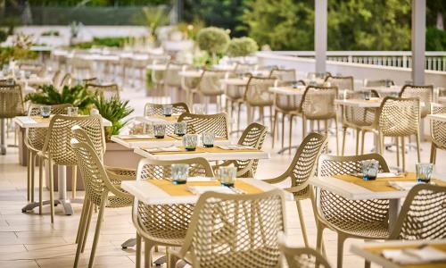 a row of tables and chairs in a restaurant at Aminess Vival Port9 Resort in Korčula