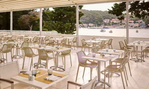a row of tables and chairs on a patio at Aminess Vival Port9 Resort in Korčula
