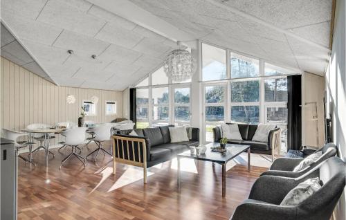 a living room with couches and a table at Holiday Home Hybenvangen Oksbøl Denm in Oksbøl