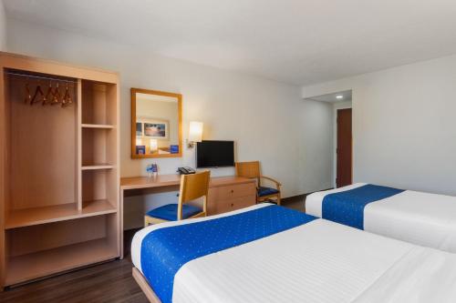 a hotel room with two beds and a desk at City Express by Marriott Tuxtla Gutiérrez in Tuxtla Gutiérrez