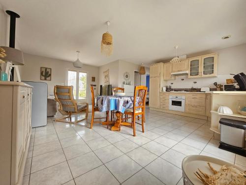 une cuisine et une salle à manger avec une table et des chaises dans l'établissement Maison récente 5 pers, proche mer et bourg, jardin, barbecue, wifi, animaux sur demande - FR-1-476-165, à Grues