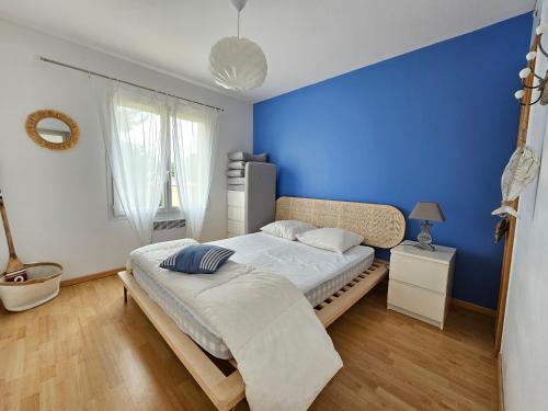 une chambre avec un mur bleu et un lit dans l'établissement Maison récente 5 pers, proche mer et bourg, jardin, barbecue, wifi, animaux sur demande - FR-1-476-165, à Grues