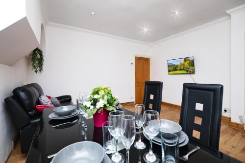a dining room with a table with wine glasses at Immaculate Condition 3 Bed En-Suite Refurbished House in Goodmayes