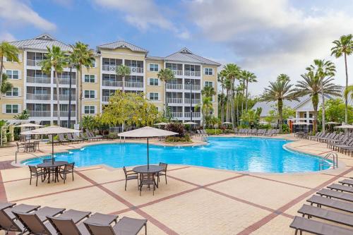 a pool with tables and chairs in front of a building at Sheraton Vistana Villages Resort Villas, I-Drive Orlando in Orlando