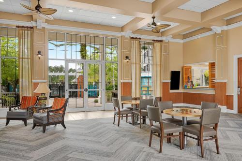 a lobby with tables and chairs and windows at Sheraton Vistana Villages Resort Villas, I-Drive Orlando in Orlando