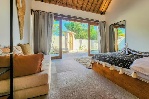a bedroom with a bed and a couch at Villa Manouch in Nusa Lembongan