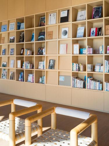 a library with a bench and shelves of books at Shonai Hotel Suiden Terrasse in Tsuruoka