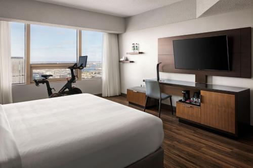 a hotel room with a bed and a desk with a television at Minneapolis Marriott City Center in Minneapolis