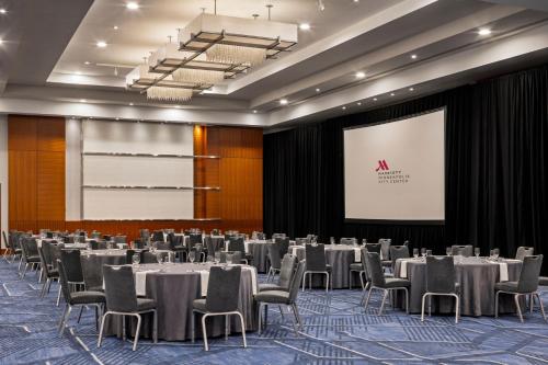 a conference room with tables and chairs and a screen at Minneapolis Marriott City Center in Minneapolis