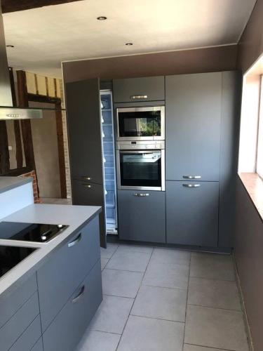 une cuisine avec des appareils en acier inoxydable et des armoires blanches dans l'établissement El Dorado, à Genneville