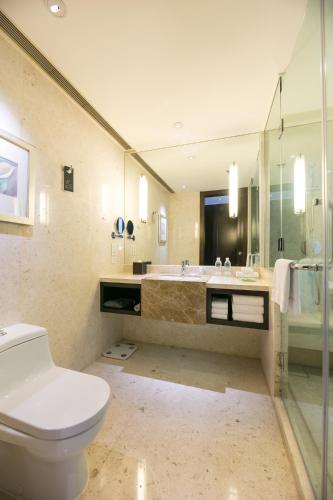 a bathroom with a toilet and a sink and a tub at Courtyard by Marriott Hangzhou Wulin in Hangzhou
