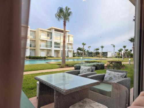 a patio with a table and chairs and a building at CASA BAY BEACH OMK 3 in Sidi Rahal