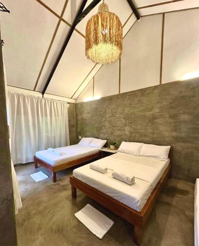 a room with two beds and a chandelier at Bohol Island Homestay in Dauis
