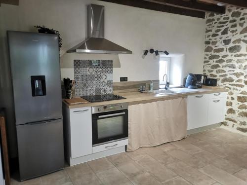 Il comprend une cuisine équipée d'un réfrigérateur et d'une cuisinière. four supérieur dans l'établissement Gîte charmant à la campagne, idéal pour famille - accès handicapé, terrasse, BBQ, proche randonnées - FR-1-489-535, à Bourbon-lʼArchambault