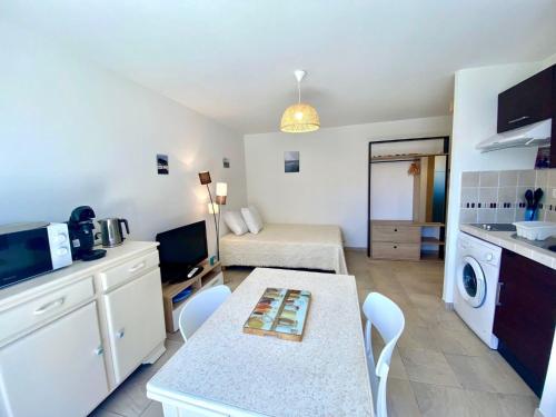 - une petite cuisine avec une table et un lit dans l'établissement Studio Coquet à Mèze : Climatisé, Près du Parc, Terrasse, Proche Plage et Port - FR-1-604-51, à Mèze