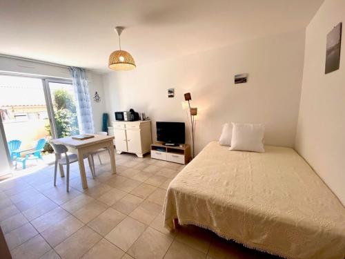 une chambre avec un lit, une table et un bureau dans l'établissement Studio Coquet à Mèze : Climatisé, Près du Parc, Terrasse, Proche Plage et Port - FR-1-604-51, à Mèze