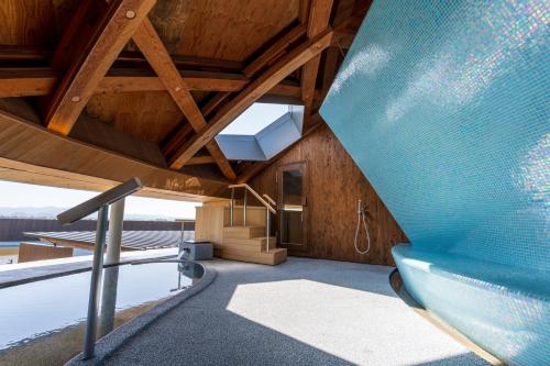 a room with a blue couch and a staircase in a house at Shonai Hotel Suiden Terrasse in Tsuruoka