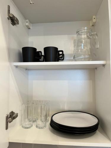 a bathroom with a toilet and glasses on a shelf at Departamento equipado Asunción, Las Mercedes in Asuncion