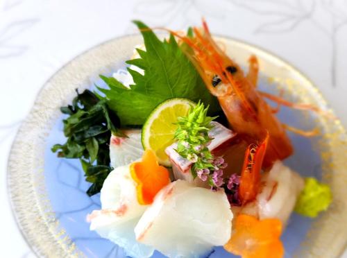 a plate of food with fish and vegetables on it at Bellevue Garden Hotel Kansai International Airport in Izumi-Sano