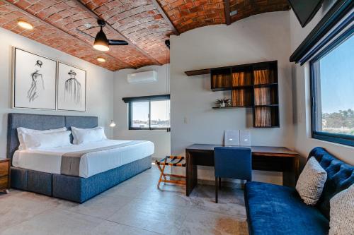 a bedroom with a bed and a desk and a couch at Hotel NG in Ameca