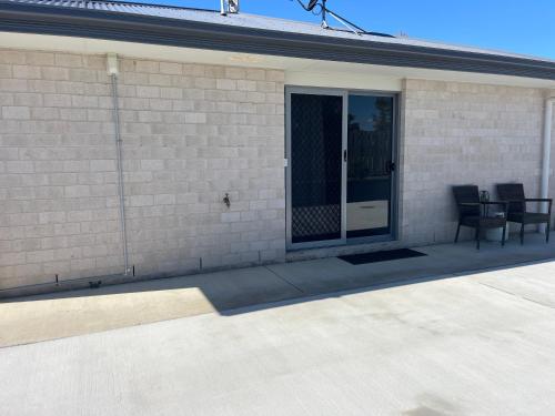 a patio with two chairs next to a building at Freyjas Guest Suite in Curra
