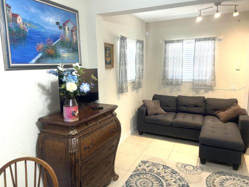 un salon avec un canapé et un canapé et une table dans l'établissement Casa Historica, a cozy 1940 cottage in Delray Beach, FL, à Delray Beach