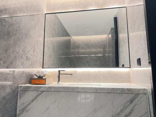 a bathroom with a sink and a mirror at Shanghai Maybeours Hotel in Fengxian