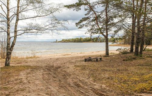 a bench sitting on a beach near the water at 3 Bedroom Pet Friendly Home In Säffle in Säffle