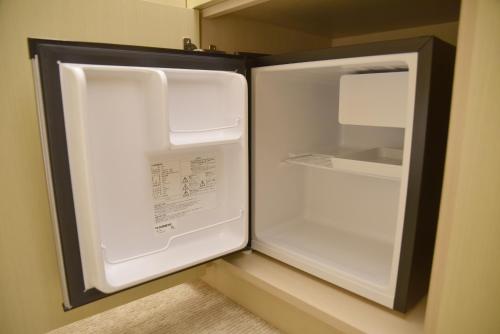 an empty refrigerator with its door open in a room at Shonai Hotel Suiden Terrasse in Tsuruoka