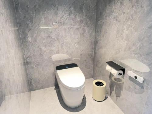 a bathroom with a white toilet and a sink at Shanghai Maybeours Hotel in Fengxian