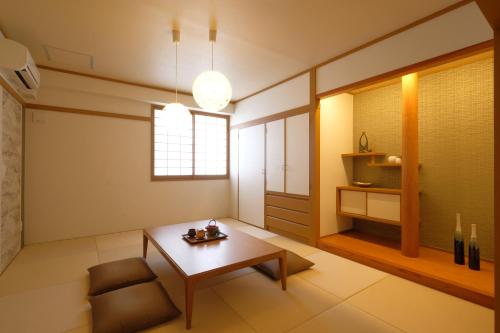 a living room with a table and a chair at 国際通りまで車で5分 那覇空港まで車で8分 最大15名 As bld in Makishimachi