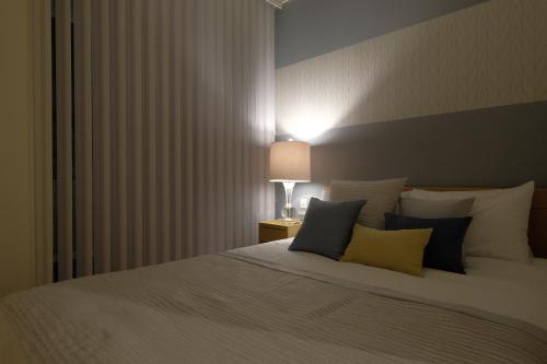 a bedroom with a bed with blue and yellow pillows at 国際通りまで車で5分 那覇空港まで車で8分 最大15名 As bld in Makishimachi