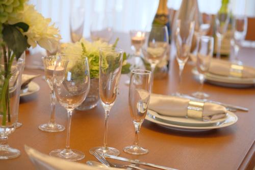 a table with wine glasses and plates on it at 国際通りまで車で5分 那覇空港まで車で8分 最大15名 As bld in Makishimachi