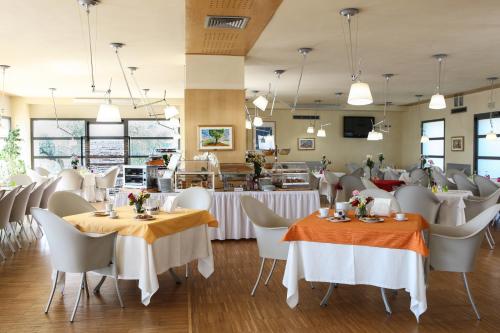 a dining room with white tables and chairs at Grand Hotel Garden in Barile
