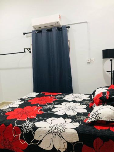a bedroom with a bed with a black and red blanket at Merang Jetty Homestay in Baroh Pahlawan