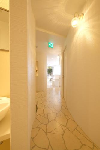 a bathroom with a hallway with a sink and a toilet at 国際通りまで車で5分 那覇空港まで車で8分 最大15名 As bld in Makishimachi