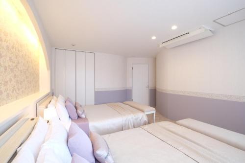 a small room with two beds and a window at 国際通りまで車で5分 那覇空港まで車で8分 最大15名 As bld in Makishimachi