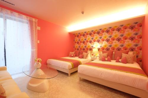 a bedroom with two beds and a glass table at 国際通りまで車で5分 那覇空港まで車で8分 最大15名 As bld in Makishimachi