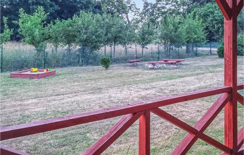 a field with picnic tables and a fence at Nice Stacaravan In Retowo 4 in Gardna Wielka