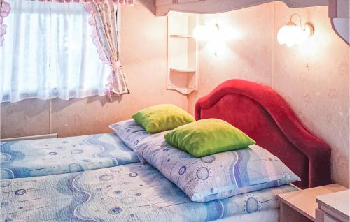 a bedroom with a bed with two pillows on it at Nice Stacaravan In Retowo 4 in Gardna Wielka