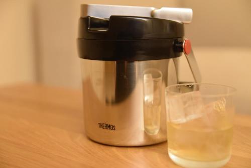 a coffee maker and a glass of water on a table at Shonai Hotel Suiden Terrasse in Tsuruoka