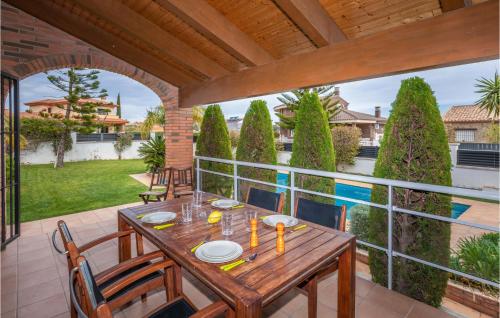 a patio with a wooden table and chairs on a balcony at Cozy Home In Hospitalet De Linfant in Hospitalet de l'Infant