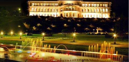 a building with a fountain in front of it at night at Royal Orchid Brindavan Garden Mysore in Belagula