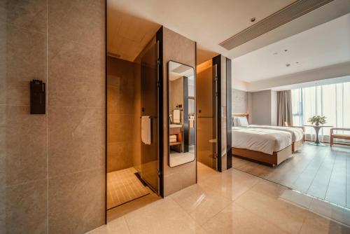 a hotel room with a bed and a shower at UrCove By HYATT Chengdu Wenshu Monastery in Chengdu